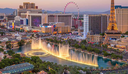 Las Vegas Strip at dusk with Bellagio fountains, casinos, and hotels.
