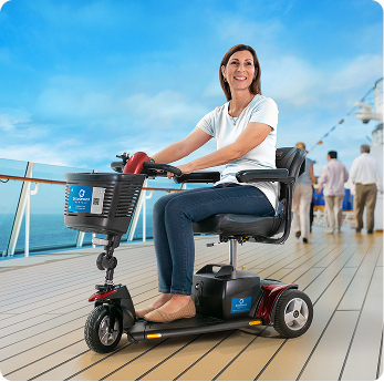 Woman on a red mobility scooter smiles on a cruise ship deck with ocean in background.